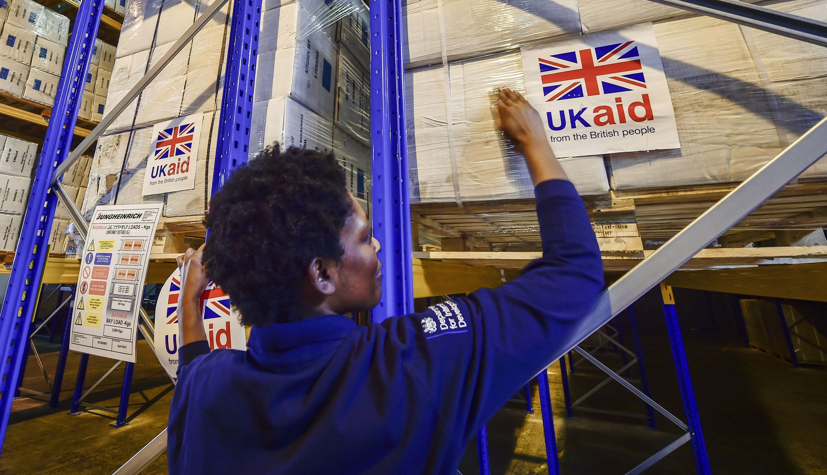 2014年12月8日，后勤官员贝弗利·萨蓬（Beverley Sarpong）的文件照片，将英国援助贴在载有英国人道主义援助物资的货盘上，运往位于肯布尔科特沃尔德机场的英国国际发展部英国灾难响应行动中心。